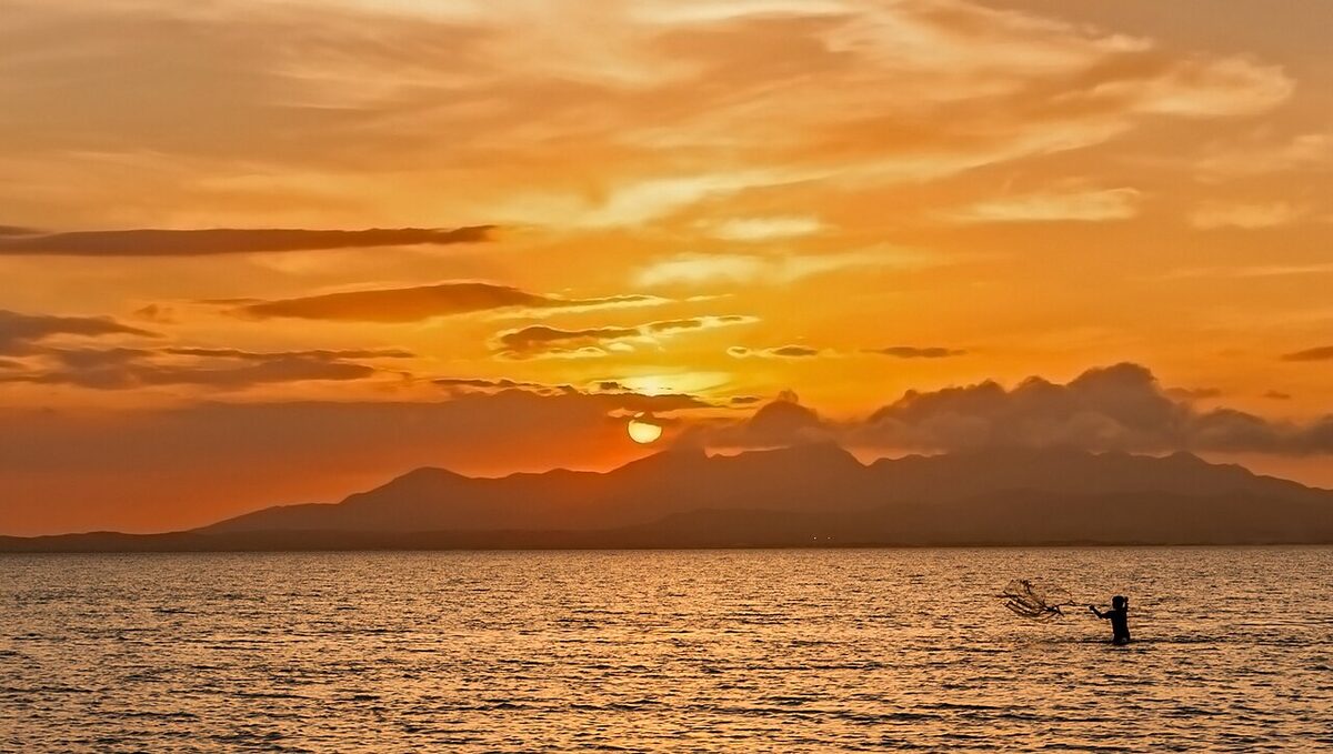 A golden sunset over calm open water